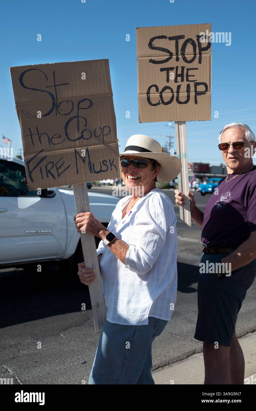 Manifestanti con cartelli che deridono Elon Musk e le buffonate DEL DOGE dell'amministrazione Trump, nonché cartelli con anti-TESLA, presso la concessionaria Tesla di Tucson, Arizona Foto Stock