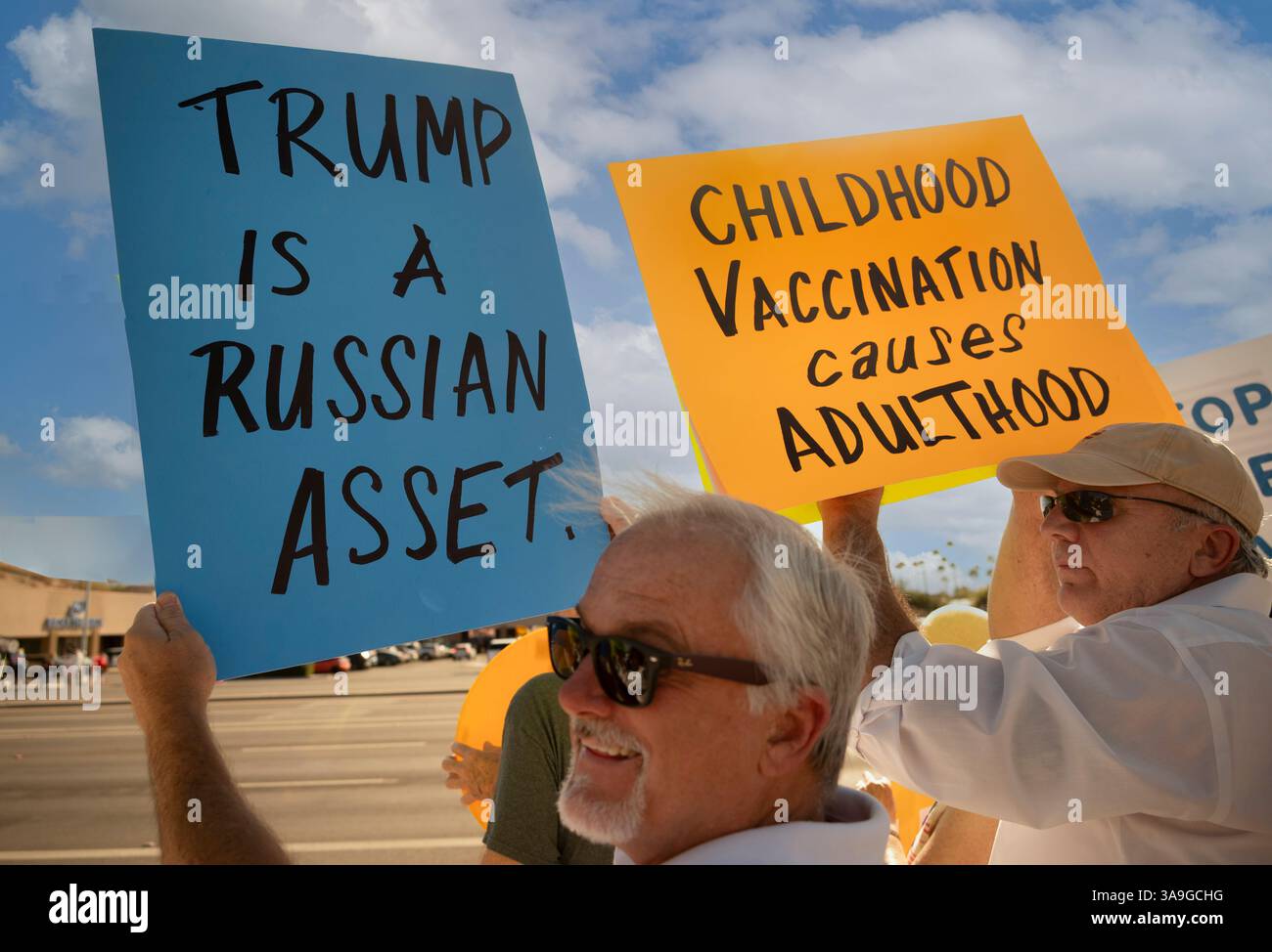 Manifestanti con cartelli che deridono Elon Musk e le buffonate DEL DOGE dell'amministrazione Trump, nonché cartelli con anti-TESLA, presso la concessionaria Tesla di Tucson, Arizona Foto Stock