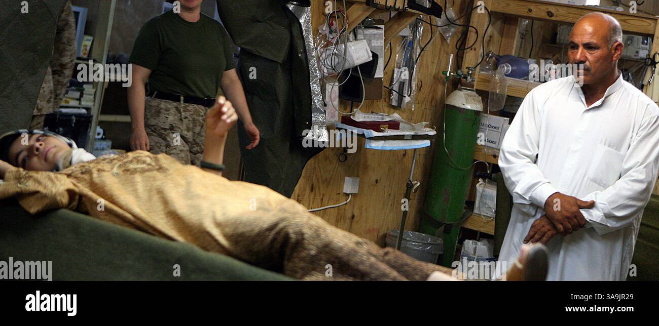 10 agosto 2006; al Qa'im, IRAQ; Ahmed, un insegnante di scuola di 46 anni a Karabilah osserva pazientemente la figlia di 12 anni, Hadael, che attende le sue medicine settimanali in una struttura medica militare degli Stati Uniti. Hadael ha un disperato bisogno di un intervento chirurgico salvavita. Hadael soffre di una malattia chiamata "Oxalosis", che causa insufficienza renale permanente. Una recente spedizione di medicine per aiutare a guadagnare tempo per la ragazza è stata recentemente donata attraverso agenzie non governative statunitensi e sta aiutando a mantenerla in vita, fino a quando non sarà trovato un donatore di organi. Il suo caso ha recentemente attirato l'attenzione negli Stati Uniti dopo diversi non-prof Foto Stock