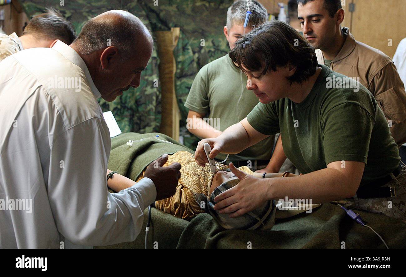 10 agosto 2006; al Qa'im, IRAQ; Ahmed, un insegnante di scuola di 46 anni a Karabilah, conforta sua figlia di 12 anni, Hadael, mentre Navy Cmdr. Tara J. Zieber, controlla i suoi segni vitali. Ha un disperato bisogno di un intervento chirurgico salvavita. Hadael soffre di una malattia chiamata "Oxalosis", che causa insufficienza renale permanente. Una recente spedizione di medicine per aiutare a guadagnare tempo per la ragazza è stata recentemente donata attraverso agenzie non governative statunitensi e sta aiutando a mantenerla in vita, fino a quando non sarà trovato un donatore di organi. Il caso di Hadael ha recentemente attirato l'attenzione negli Stati Uniti dopo diverse organizzazioni no-profit A. Foto Stock