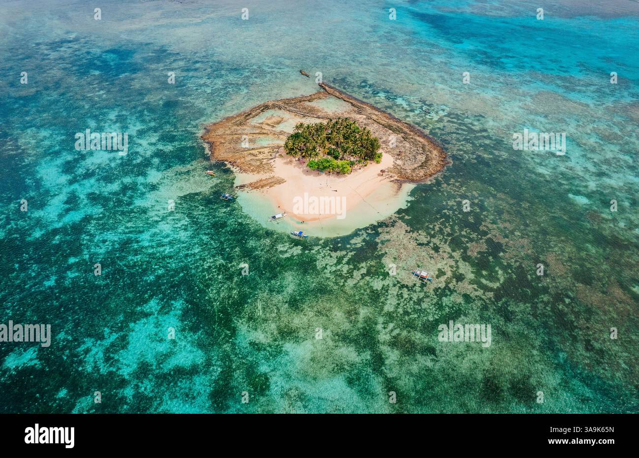 Vista aerea dell'isola di Guyam, Siargao, Una piccola e bellissima isola circondata da acque cristalline, spiagge di sabbia bianca e lussureggianti palme Foto Stock