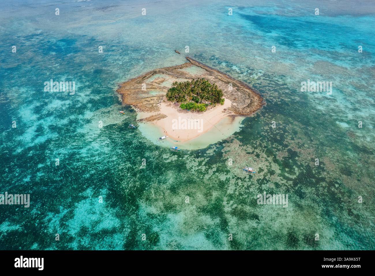 Vista aerea dell'isola di Guyam, Siargao, Una piccola e bellissima isola circondata da acque cristalline, spiagge di sabbia bianca e lussureggianti palme Foto Stock