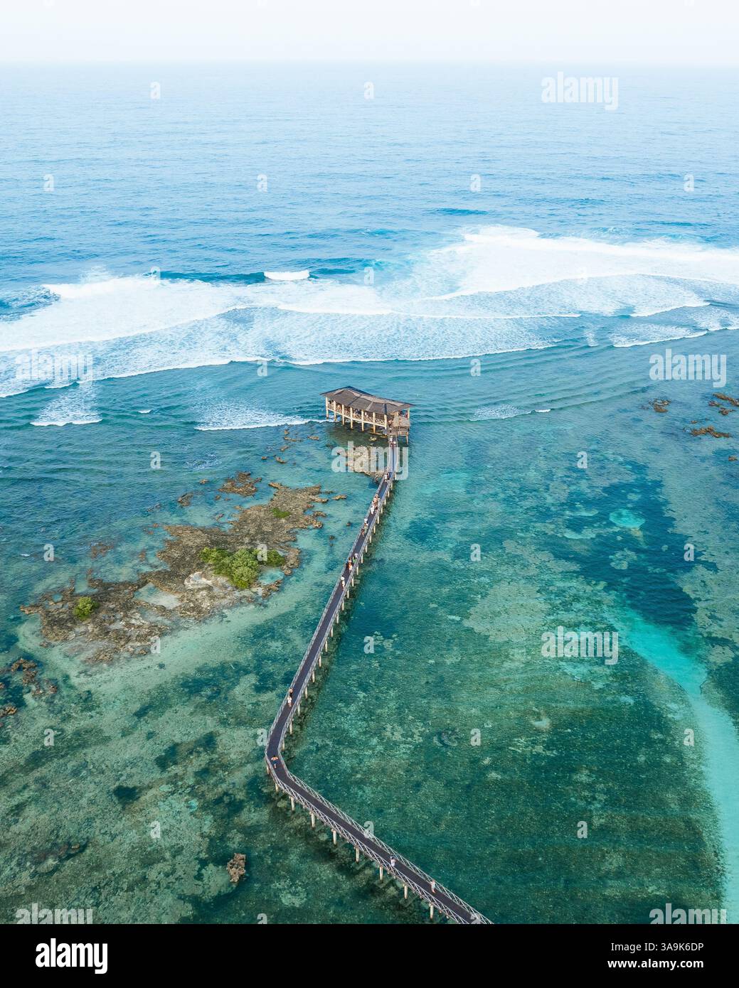 Vista aerea mozzafiato della spiaggia Cloud 9 a Siargao: Una splendida distesa di sabbia bianca, acque turchesi e una passeggiata panoramica in legno sull'Ocea Foto Stock