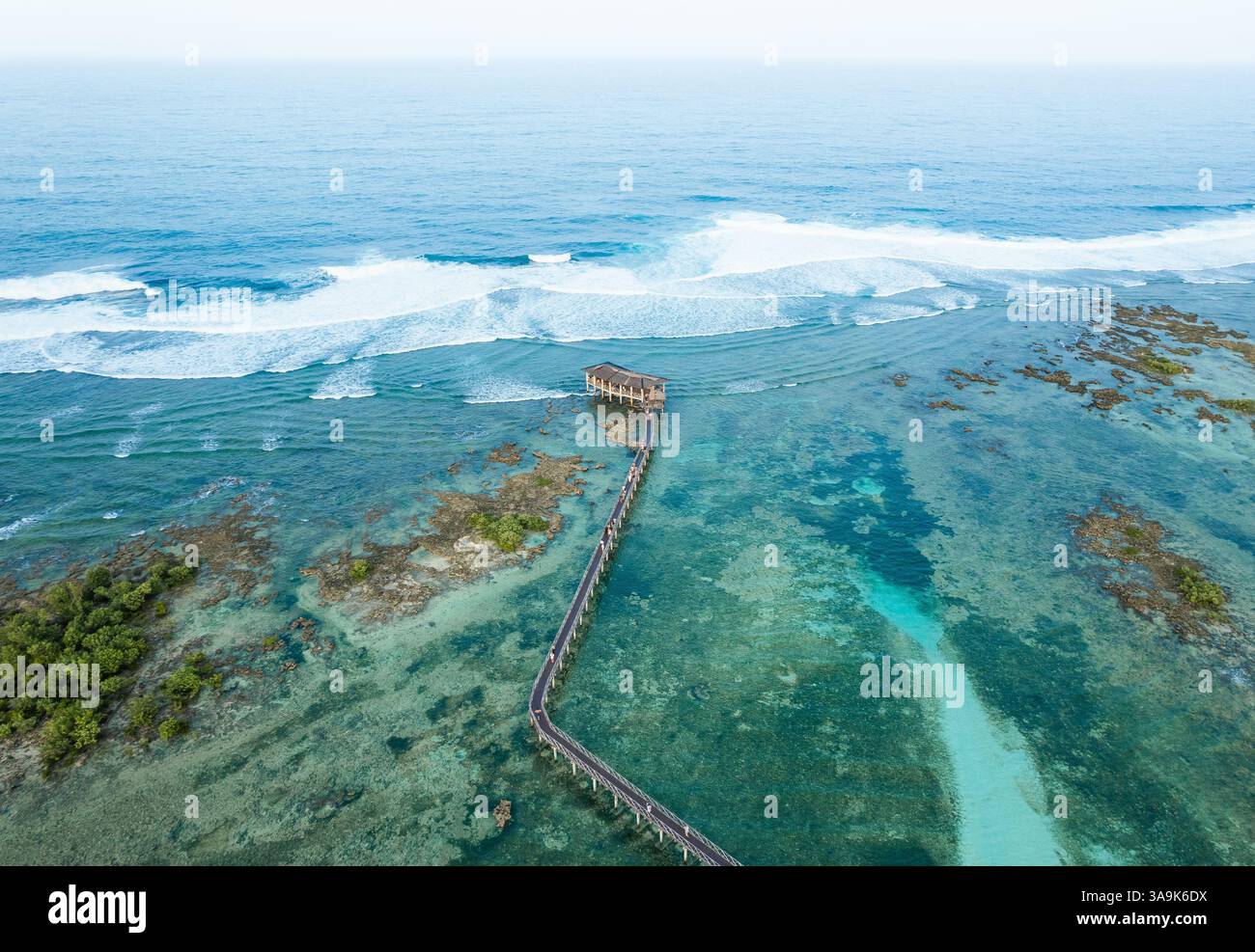 Vista aerea mozzafiato della spiaggia Cloud 9 a Siargao: Una splendida distesa di sabbia bianca, acque turchesi e una passeggiata panoramica in legno sull'Ocea Foto Stock