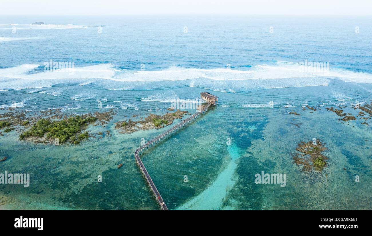 Vista aerea mozzafiato della spiaggia Cloud 9 a Siargao: Una splendida distesa di sabbia bianca, acque turchesi e una passeggiata panoramica in legno sull'Ocea Foto Stock