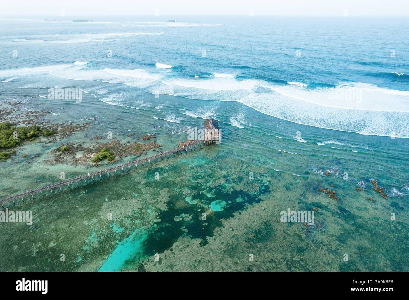 Vista aerea mozzafiato della spiaggia Cloud 9 a Siargao: Una splendida distesa di sabbia bianca, acque turchesi e una passeggiata panoramica in legno sull'Ocea Foto Stock