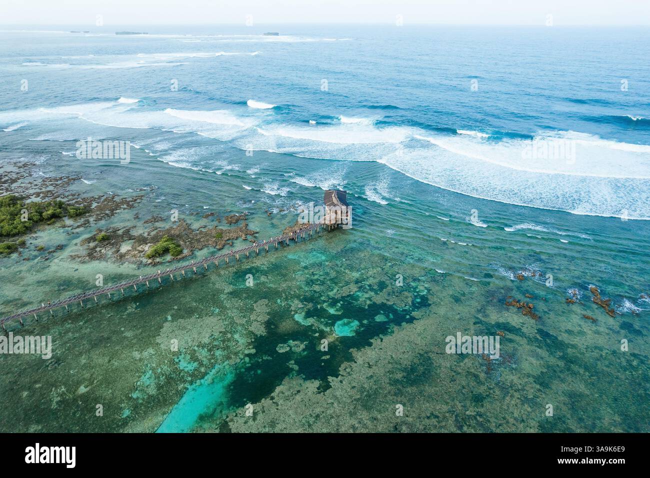 Vista aerea mozzafiato della spiaggia Cloud 9 a Siargao: Una splendida distesa di sabbia bianca, acque turchesi e una passeggiata panoramica in legno sull'Ocea Foto Stock