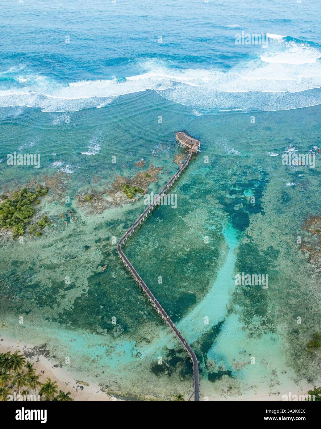 Vista aerea mozzafiato della spiaggia Cloud 9 a Siargao: Una splendida distesa di sabbia bianca, acque turchesi e una passeggiata panoramica in legno sull'Ocea Foto Stock