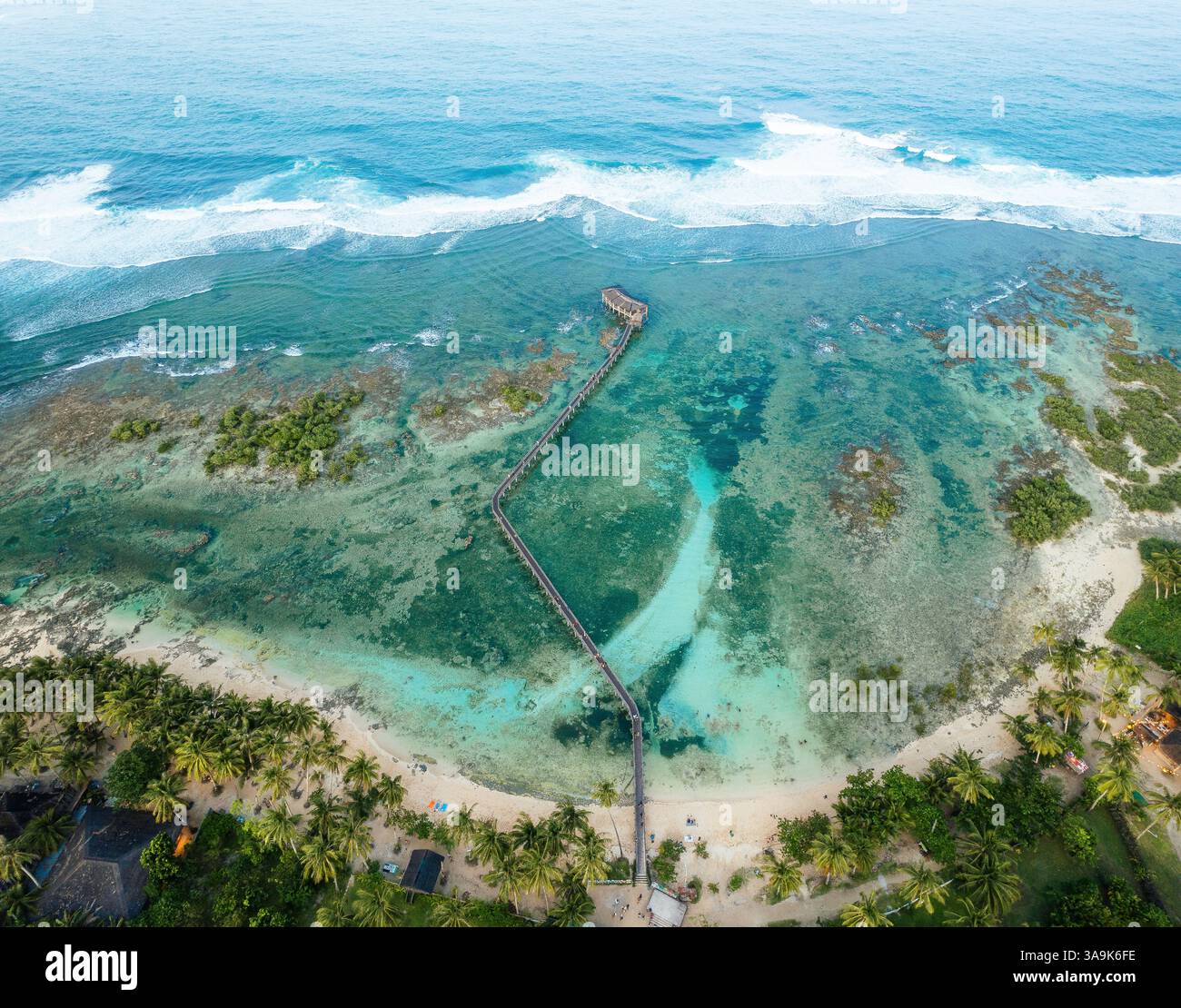 Vista aerea mozzafiato della spiaggia Cloud 9 a Siargao: Una splendida distesa di sabbia bianca, acque turchesi e una passeggiata panoramica in legno sull'Ocea Foto Stock