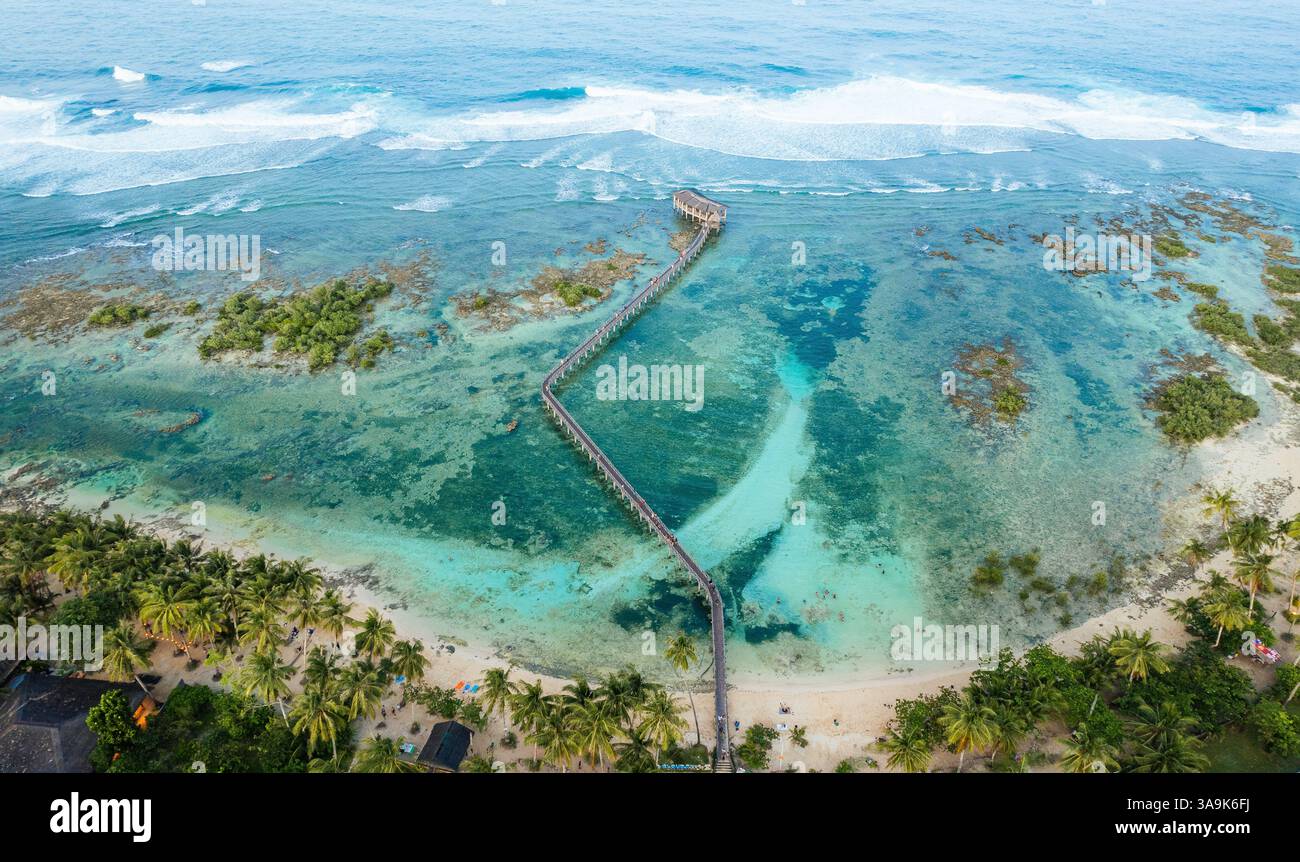 Vista aerea mozzafiato della spiaggia Cloud 9 a Siargao: Una splendida distesa di sabbia bianca, acque turchesi e una passeggiata panoramica in legno sull'Ocea Foto Stock