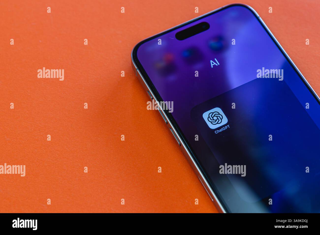 03.26.25 Lviv Ucraina Un elegante smartphone si trova su una superficie arancione brillante, mostrando un'applicazione di intelligenza artificiale sul suo schermo, catturando l'essenza della tecnologia Foto Stock