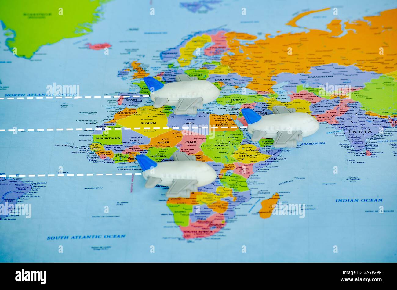 Piccoli aeroplani giocattolo sulla mappa del mondo che rappresentano viaggi o esplorazioni globali. Concetto di viaggio e destinazione. Foto Stock
