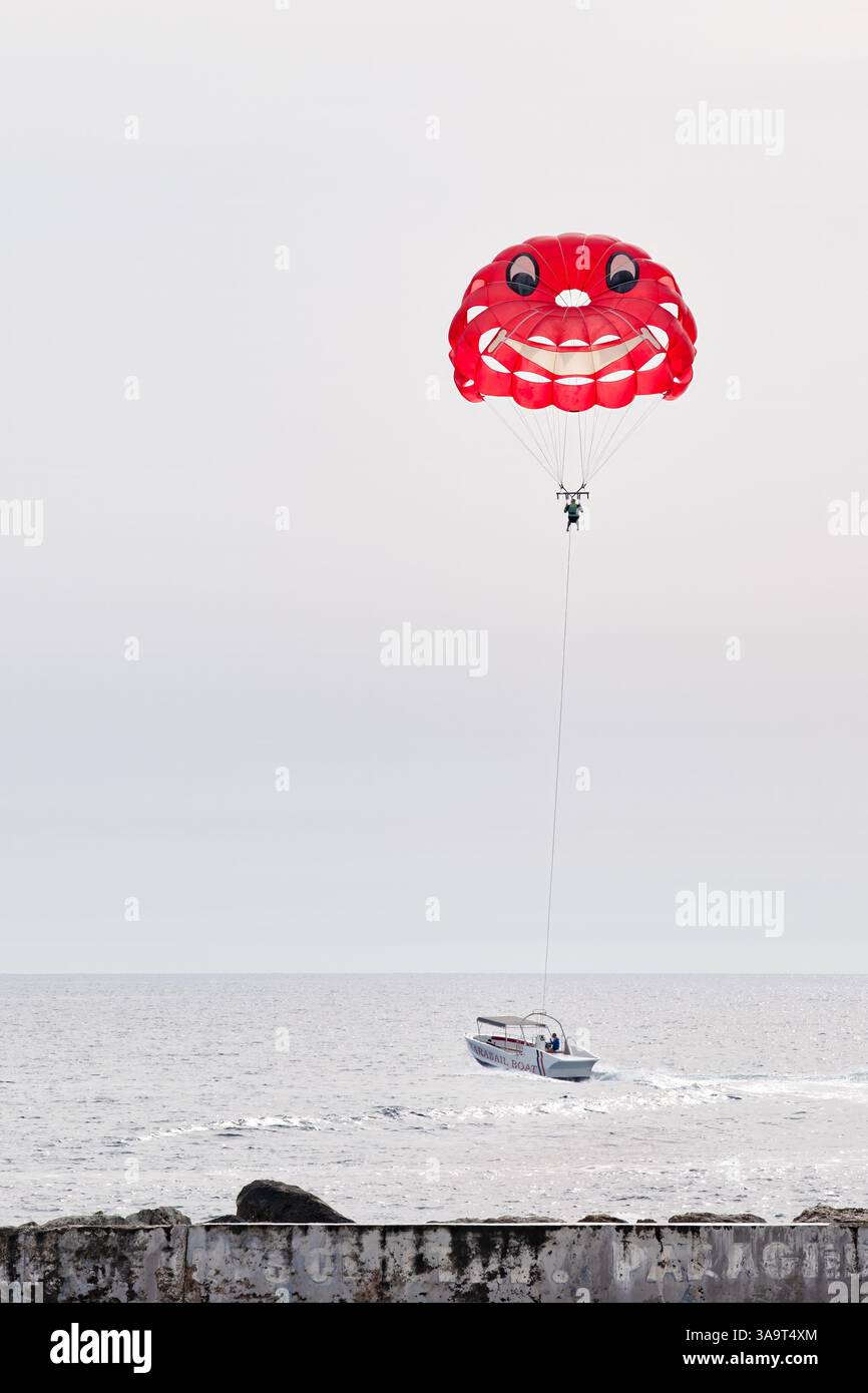 Cipro Un turista gode di un'attività di parapendio in barca durante una vacanza a Pathos Cipro la colorata tettoia si sta alzando in aria con un volto sorridente Foto Stock