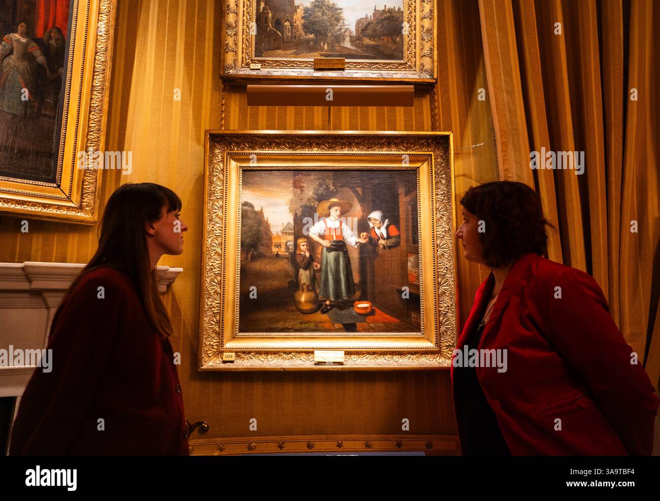 Il personale della Gallery guarda "The Milkwoman" di Nicolas Maes, durante una chiamata fotografica per la mostra "Wellington's Dutch Masterpieces" nella Piccadilly Drawing Room di Apsley House, nel centro di Londra. La mostra include opere di Nicolaes Maes, Pieter de Hooch e Jan Steen, parte della collezione di antichi maestri di proprietà di Arthur Wellesley - ex primo ministro e i duca di Wellington - che acquistò 21 dipinti olandesi poco dopo la sua famosa vittoria nella battaglia di Waterloo. La mostra aprirà martedì presso Apsley House, la residenza aristocratica del Duca acquistata nel 1816 e che si Foto Stock
