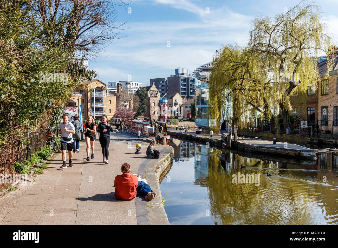 Le persone godono del caldo clima primaverile al City Road Lock (No. 5) sul Regent's Canal, Islington, Londra, Regno Unito Foto Stock
