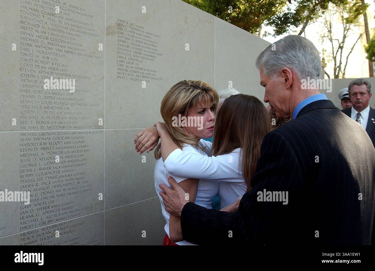 Il governatore della California Gray Davis (rt) conforta sue Schmidt e la figlia di sue Kathryn Schmidt, 11 anni dopo la cerimonia di inaugurazione del California Firefighters Memorial sabato pomeriggio al Capitol Park. Il marito di Schmidt, John ''Eric'' Schmidt è uno dei vigili del fuoco caduti sul muro. Sacramento Bee Fotografia di Jose Luis Villegas 6 aprile 2002 Sacramento Bee/ZUMA Press Foto Stock