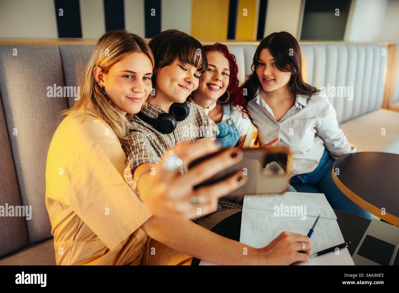 Un allegro gruppo di amici che scattano un selfie insieme in una classe, mostrando amicizia, divertimento e esperienze di vita degli studenti. Foto Stock