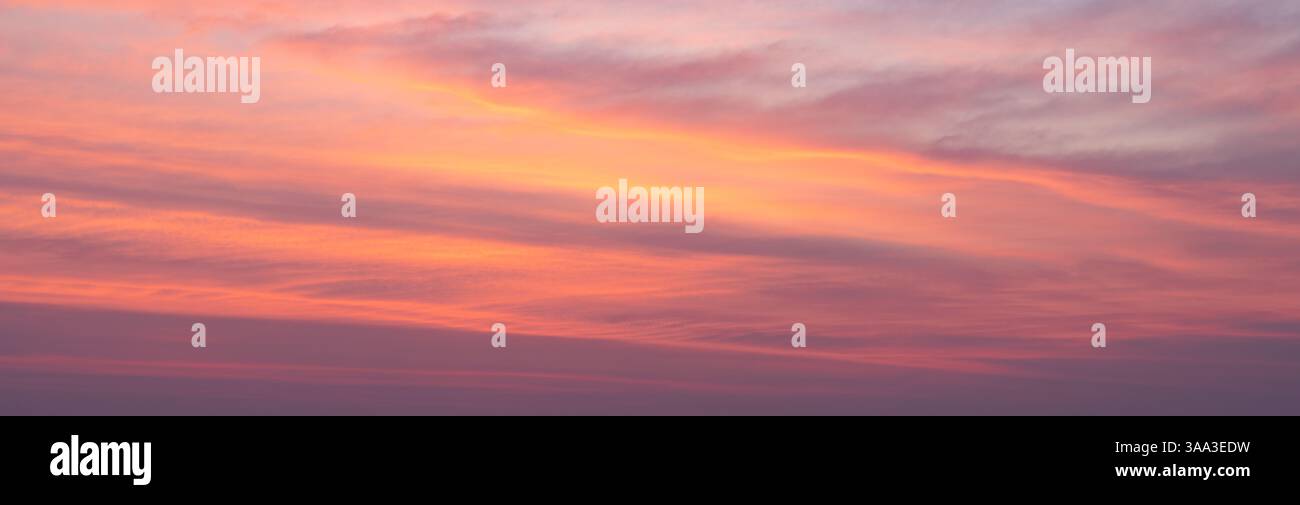 sfondo di un cielo tropicale, tonalità giallo, rosso, viola e blu. Colori dei tropici nel cielo. Foto Stock