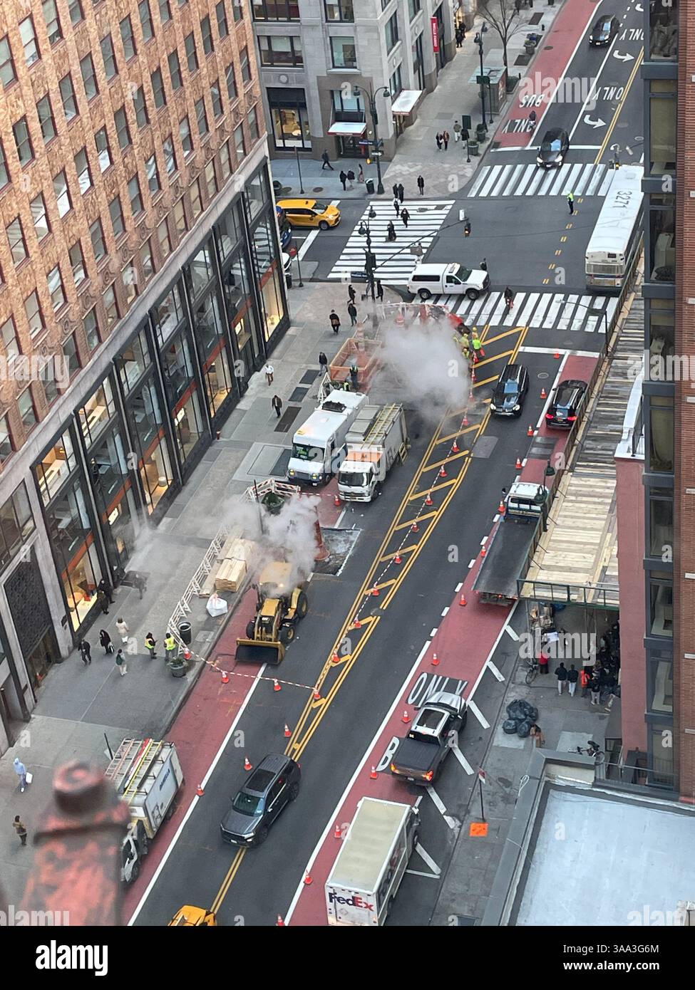 Gli addetti alla manutenzione della città riparano il tubo del vapore all'angolo di E. 34th St. In Madison Avenue, 2025, New York City, USA - Immagine stock catturata con smartphone