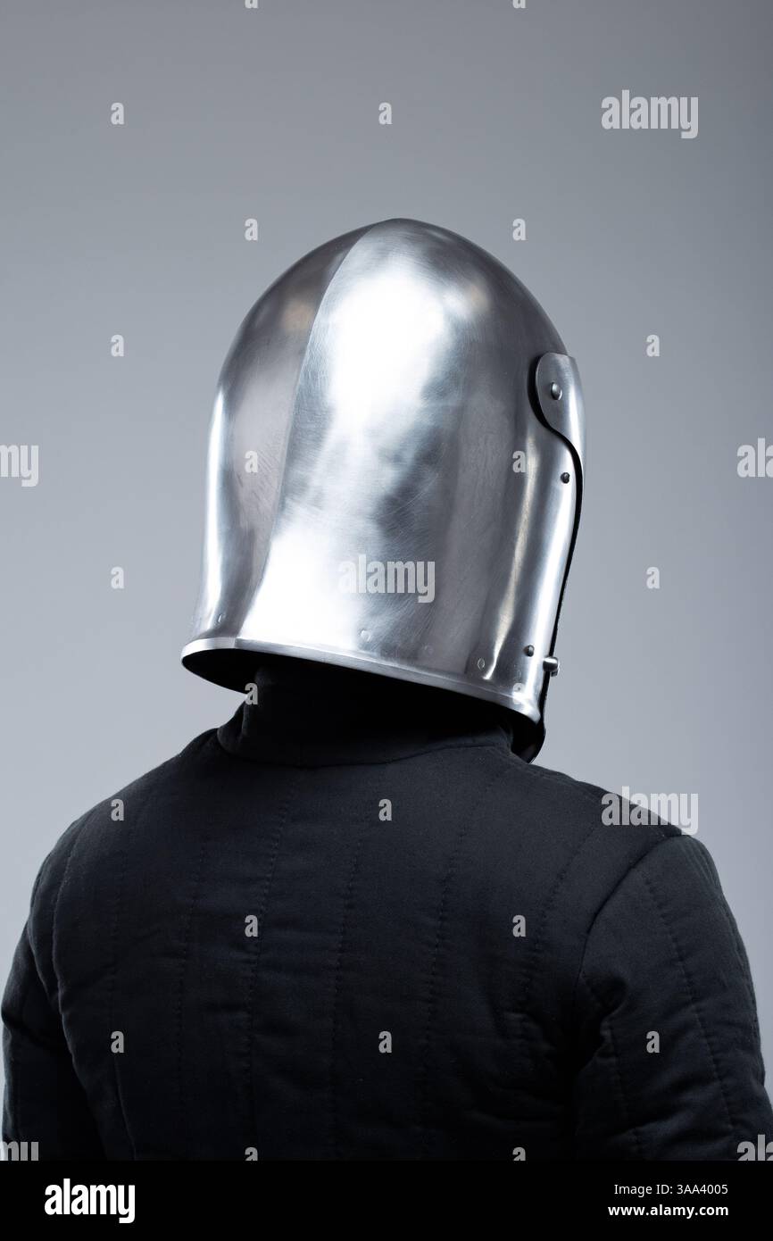 Elmetto medievale chiuso con fenditure. Casco argentato lucido che racchiude completamente la testa con fessure di visualizzazione verticali e orizzontali. Foto Stock