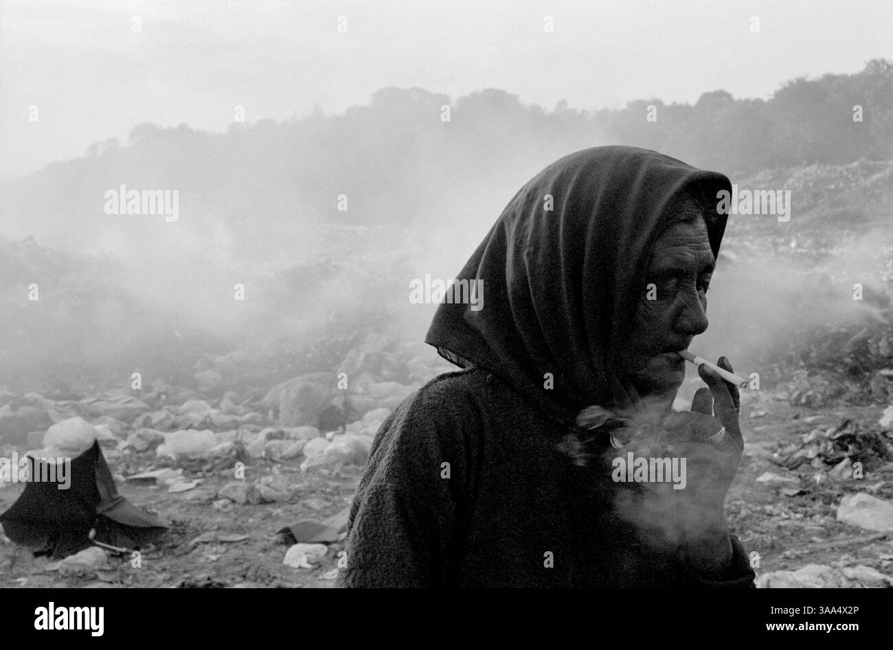 30 gennaio 2007; Ohrid-Resen, MACEDONIA; Jamela fuma una sigaretta alla fine della giornata mentre mi dice che vuole lasciare la discarica a causa del fumo della spazzatura in fiamme. Il fumo domestico è la quarta più grande causa di morte e di malattia nei paesi più poveri del mondo, ed è un assassino più grande della malaria. A livello globale, il fumo domestico uccide una persona ogni 20 secondi. I rom della classe media economicamente più riusciti si sono integrati bene con la più ampia comunità macedone, vivono negli stessi quartieri, mandano i loro figli nelle stesse scuole e gestiscono i loro cammini Foto Stock