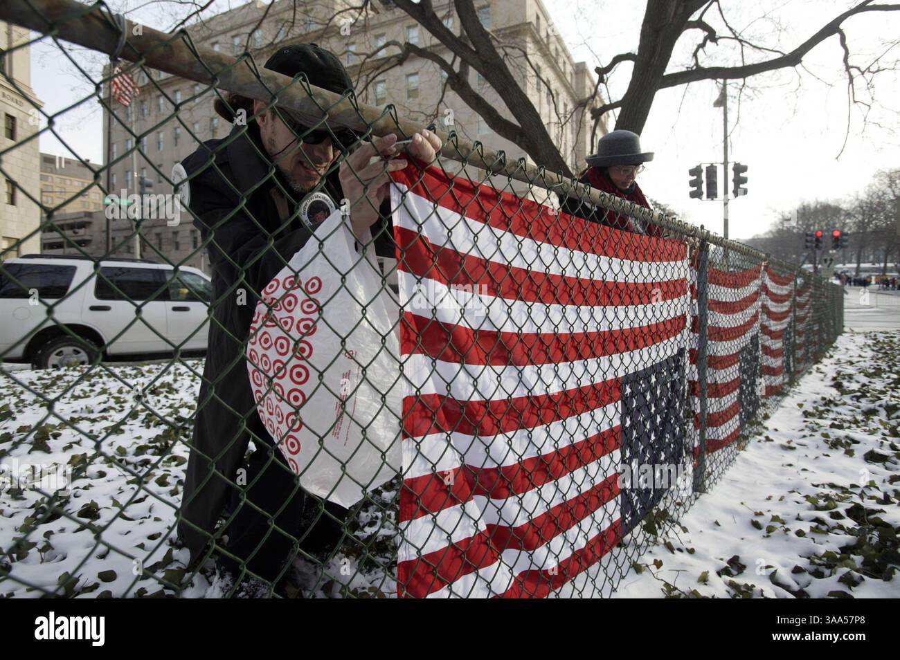 20 gennaio 2005; Washington, DC, USA; i manifestanti indipendenti SCOTT KEMPER e REGAN, entrambi di Los Angeles, appendono le bandiere capovolte intorno all'incrocio tra NW Indiana e NW 1st Street prima dell'inaugurazione. Foto Stock