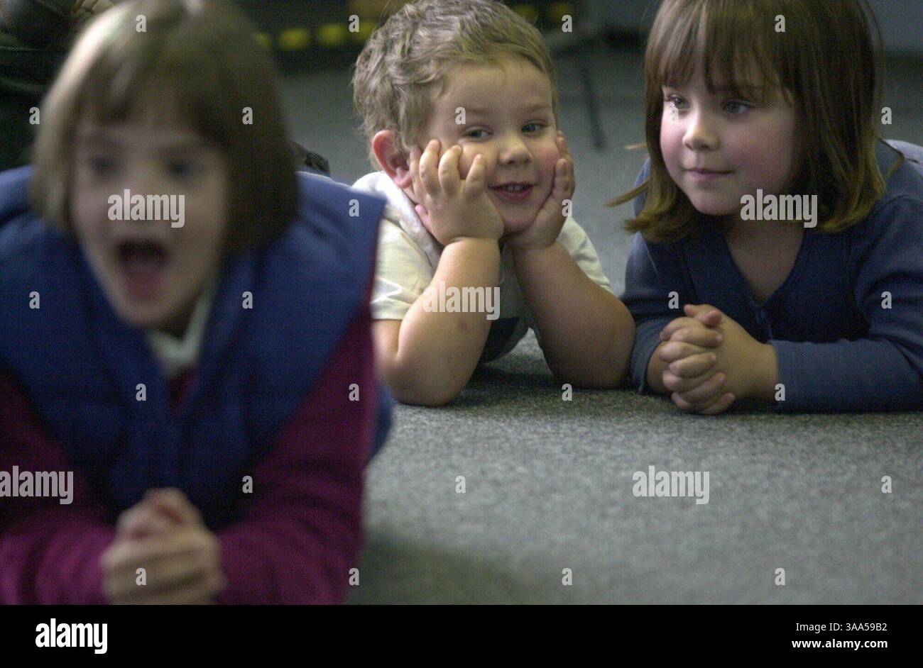 Joseph Marchand, 2 anni, che è sordo e ha appena ricevuto un impianto cocleare nell'orecchio, visto qui martedì 6 febbraio 2001 sul pavimento con sua sorella, Chloe, 4 anni, giusto, durante una visita in famiglia alla scuola CCHAT per i sordi mentre visitano una lezione di musica alla scuola. La scuola offre un modo controverso di insegnare ai bambini sordi con gli impianti non insegnando il linguaggio dei segni ma insegnando ai bambini ad ascoltare e parlare come forma di comunicazione. (Sacramento Bee/Jose M. Osorio) ID 1844 The Sacramento Bee/ZUMA Press Foto Stock