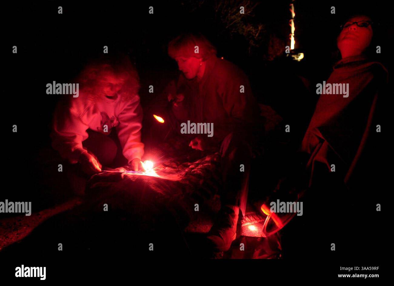 Sheila Steinberg, all'estrema sinistra, di Meadow Vista, Lynda Radzavage (cq), al centro, di Roseville, e Dell Richards (cq), di Sacramento esaminano le mappe stellari mentre aspettano la mostra di meteore Leonid presso l'Auburn State Recreation area di Auburn, CA., sabato sera, 17 novembre 2001. Tenere presente che il rosso proviene dalle luci lampeggianti e deve essere mantenuto rosso. (Sacramento Bee/Jose M. Osorio) Sacramento Bee/ZUMA Press Foto Stock