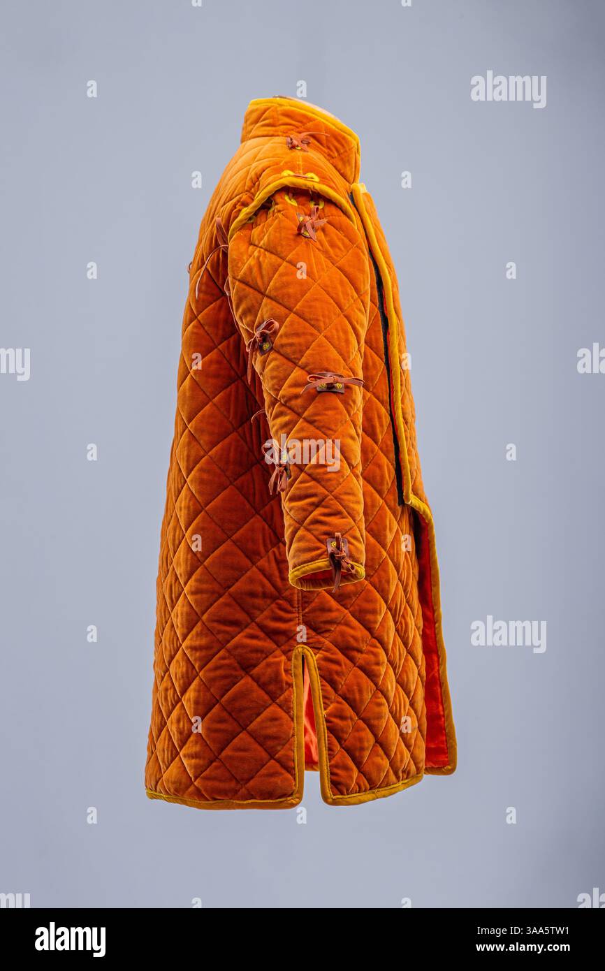 Orange Medieval Gambeson con dettagli costruttivi. Armatura trapuntata che mostra l'apertura anteriore, le cuciture diamantate e le cravatte sulle maniche e sulle spalle Foto Stock