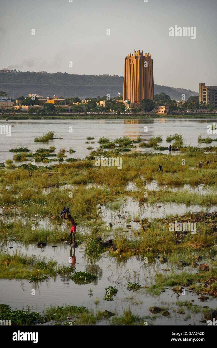 Bamako, Mali. 31 maggio 2017. Vista del fiume Niger durante la stagione calda a Bamako dalla riva destra della capitale maliana, 31 maggio 2017. Un uomo sta lavando i suoi vestiti nel fiume, che ha un flusso e un livello molto bassi durante la stagione calda. Di fronte alla riva sinistra, si può vedere la torre della Banca centrale degli Stati dell'Africa occidentale (BCEAO). - 31/05/2017 - Mali/Bamako District/Bamako - Nicolas Remene/le Pictorium credito: LE PICTORIUM/Alamy Live News Foto Stock