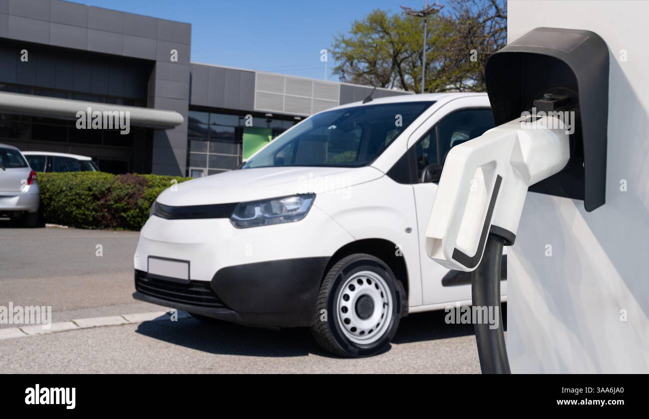 Furgone elettrico con stazione di ricarica per veicoli elettrici. Foto Stock