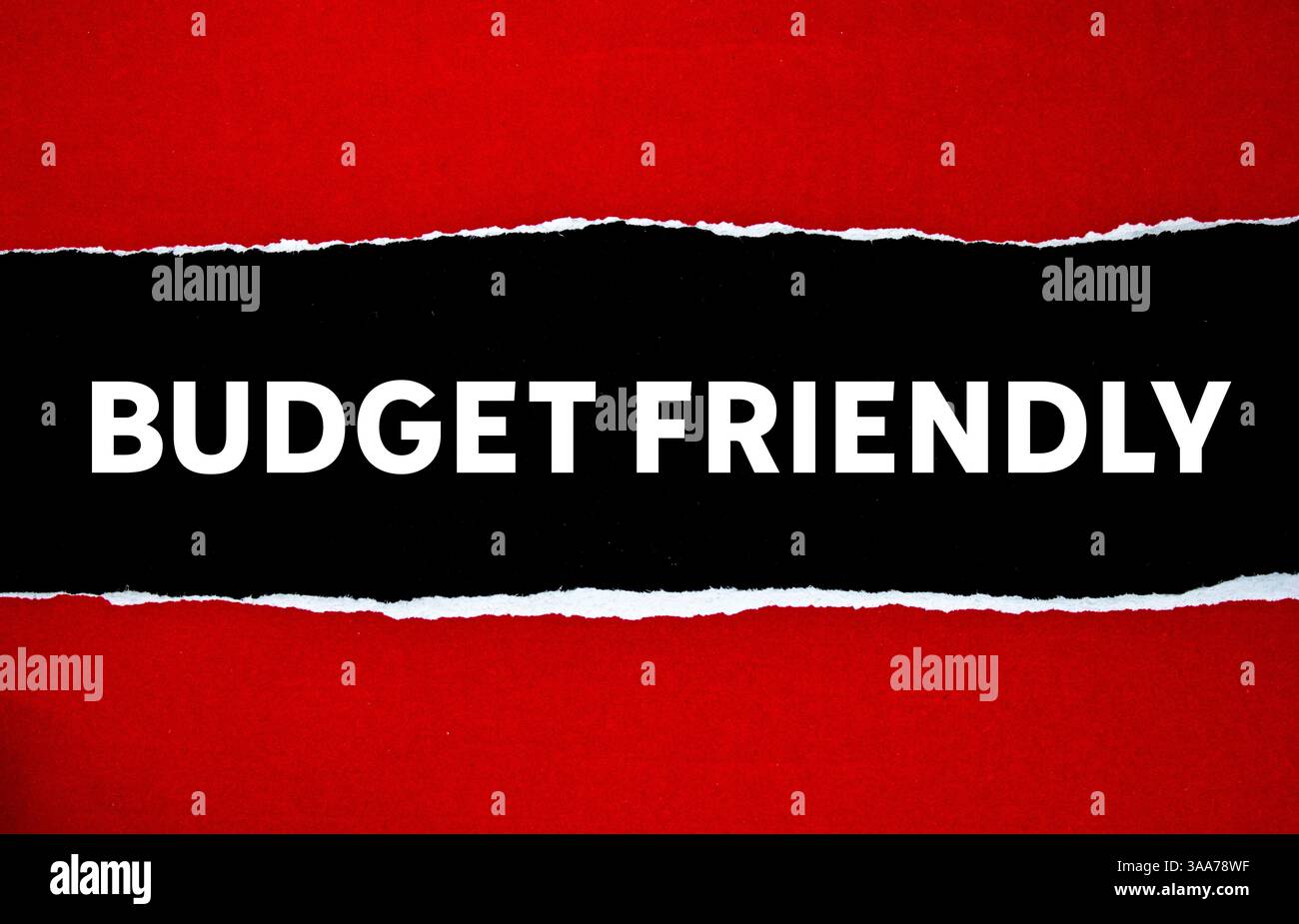 Messaggio economico scritto su carta rossa strappata su sfondo nero. Simbolo di budget concettuale. Copia spazio. Foto Stock
