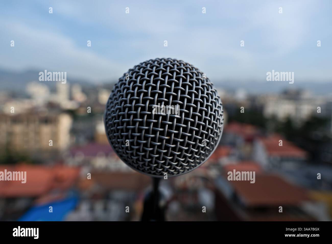 Microfono sullo sfondo della città e del cielo blu. Foto Stock