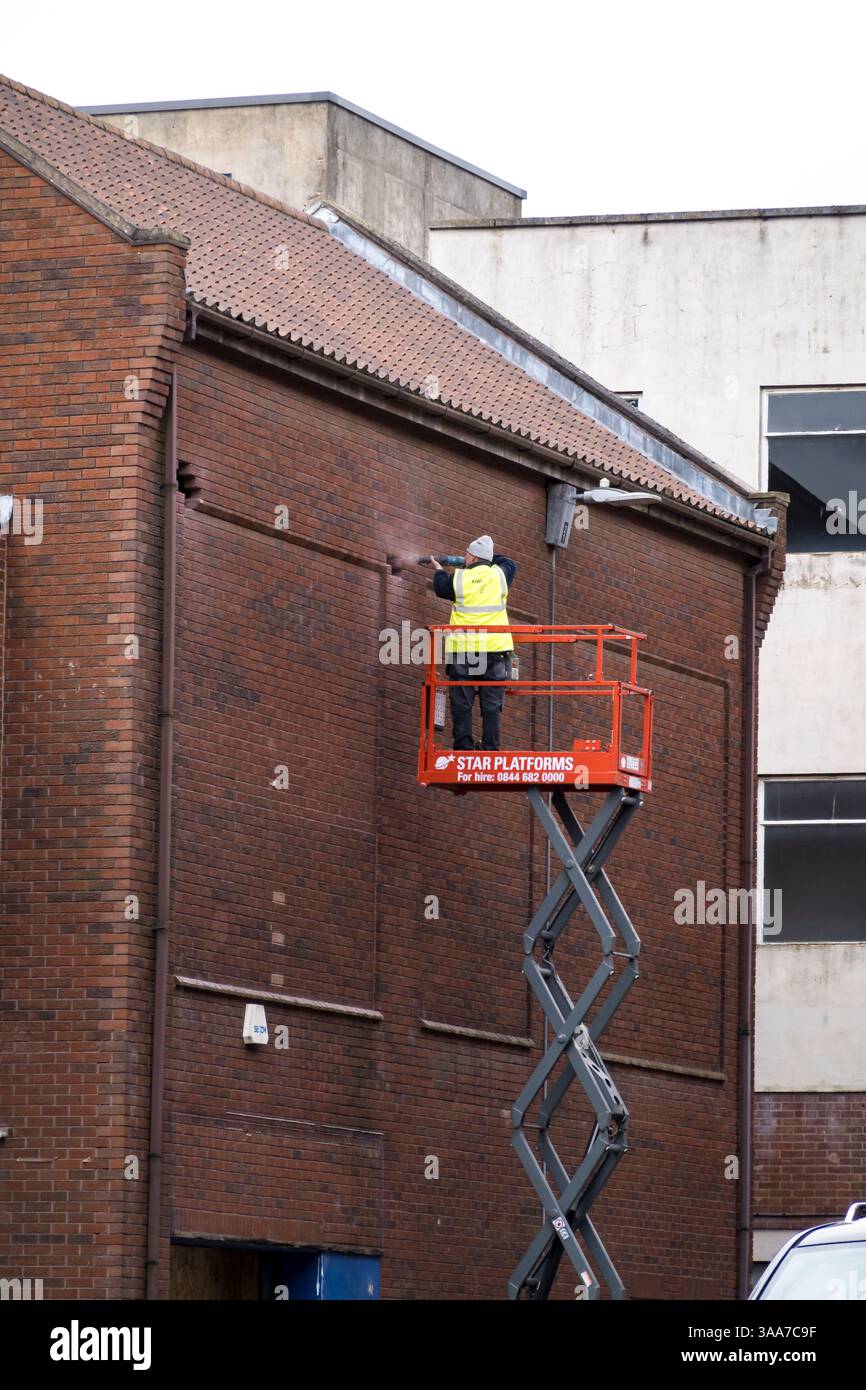 Lavoratore che taglia i mattoni dalla parete con la macchina utensile, Lincoln City, Lincolnshire, Inghilterra, Regno Unito Foto Stock