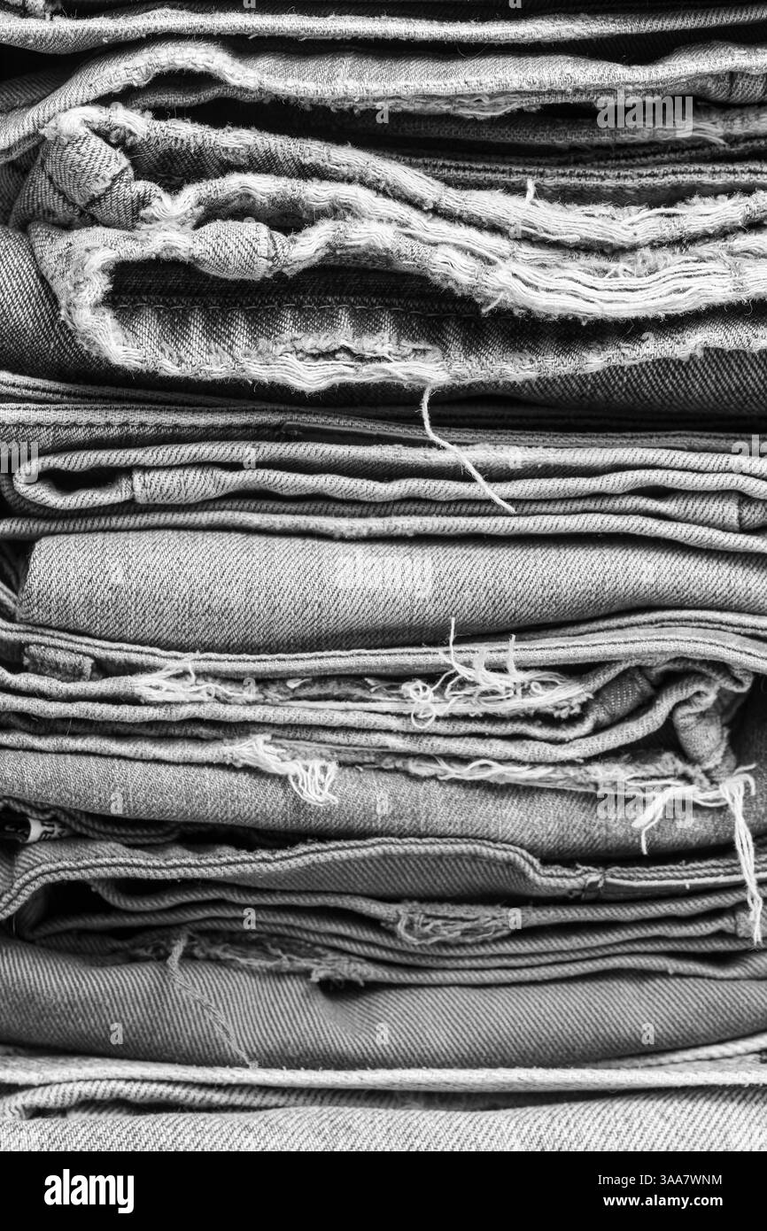 Pile di vecchi jeans come sfondo, primo piano. Bianco e nero Foto Stock