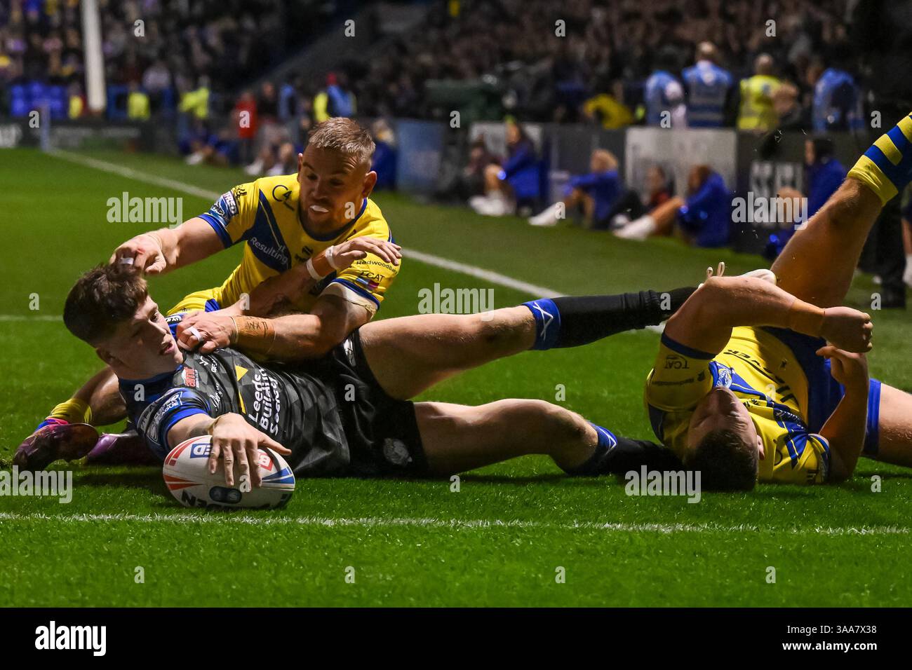 WARRINGTON, INGHILTERRA - 28 MARZO 2025: Riley Lumb dei Leeds Rhinos viene affrontato a corto della linea di meta da Matt Dufty dei Warrington Wolves durante il Betfre Foto Stock