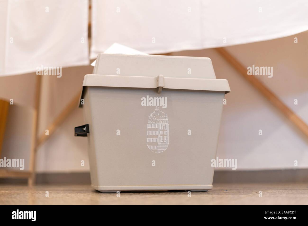 Urna con stemma ungherese e busta di voto su un tavolo Foto Stock