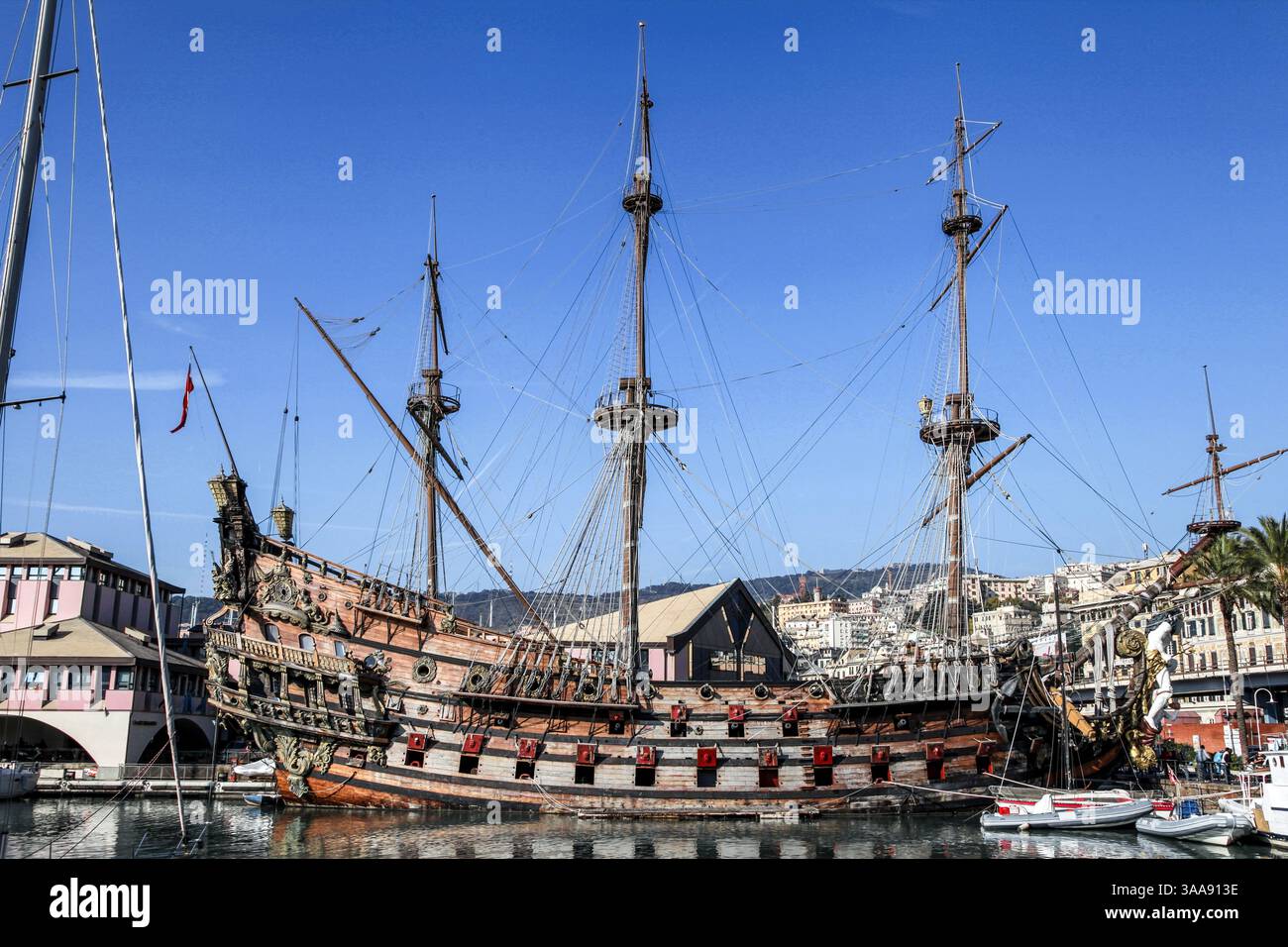 Una grande nave è ormeggiata in un porto in un acquario di Genova, Italia. Ci sono diverse barche più piccole in acqua. La nave è la più grande della zona Foto Stock