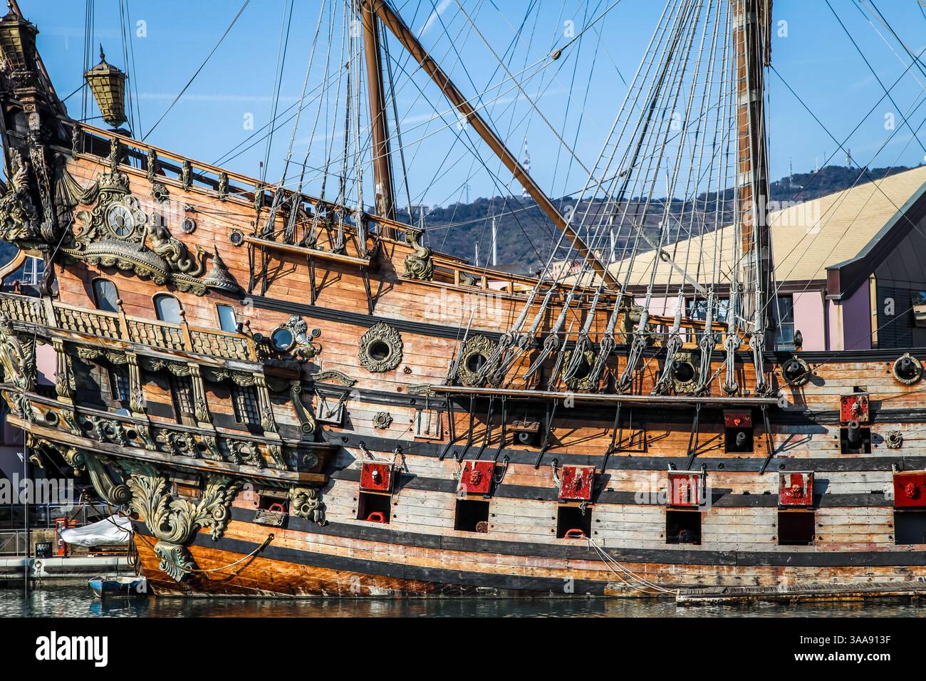 Una grande nave è ormeggiata in un porto in un acquario di Genova, Italia. Ci sono diverse barche più piccole in acqua. La nave è la più grande della zona Foto Stock