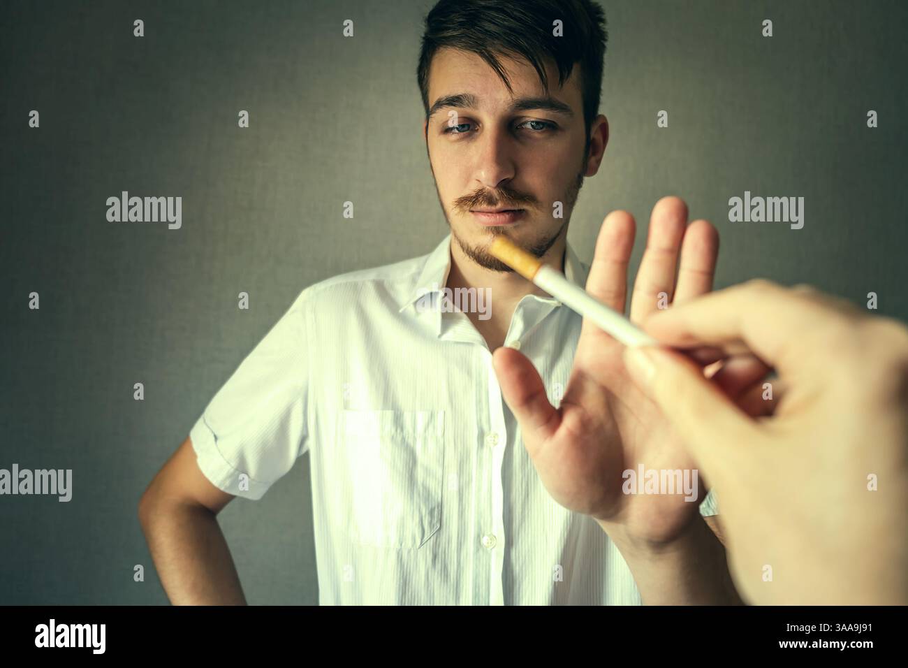 Foto tonificata di Young Man rifiuta una sigaretta in camera Foto Stock