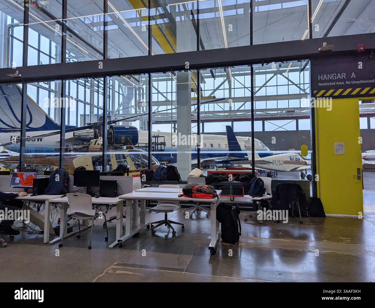 Toronto, Canada - 28 marzo 2025: Un vecchio hangar di fabbrica di aeroplani è stato convertito in un edificio universitario per studenti di aviazione Foto Stock