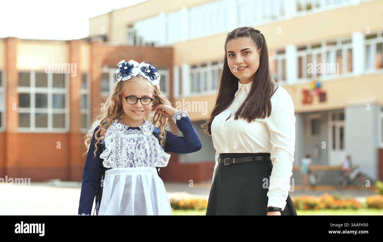 Due studentesse russe suore in posa in abiti festivi il giorno dell'inizio dell'anno scolastico. Foto Stock