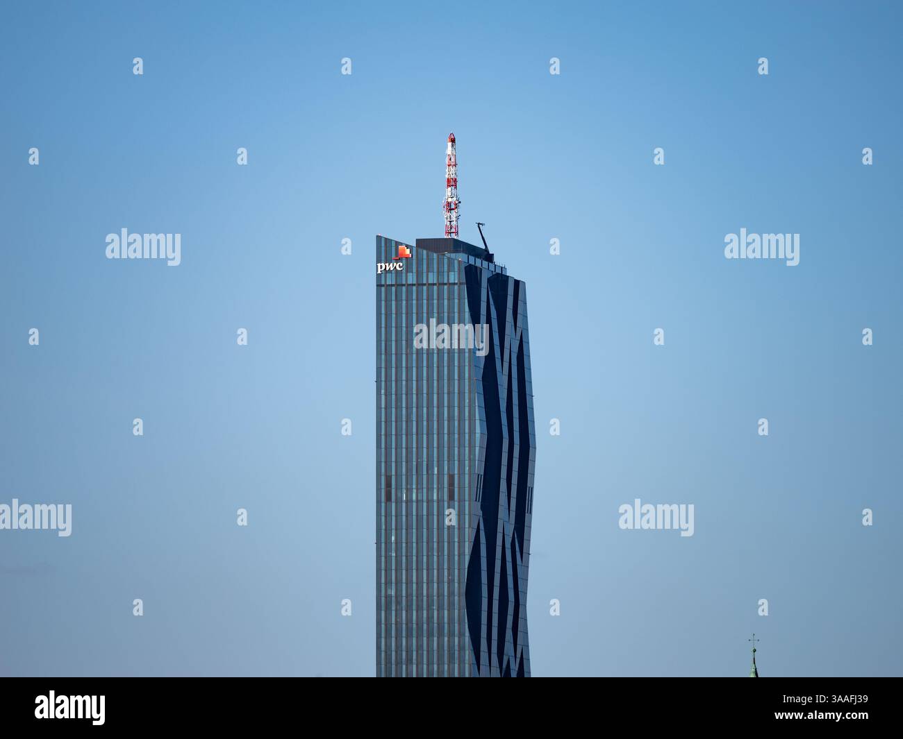 Torre della città di Donau (Torre DC 1) con il logo PwC sull'esterno. Architettura grattacielo di fronte a un cielo blu. Punto di riferimento nella città di Vienna. Foto Stock