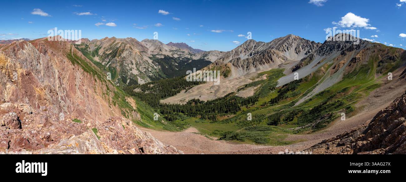 White benchmark (13.411') e White Rock Mountain (13.523') si innalzano sopra il verde fogliame del Queen Basin nella catena degli alci fuori Crested Butte CO Foto Stock