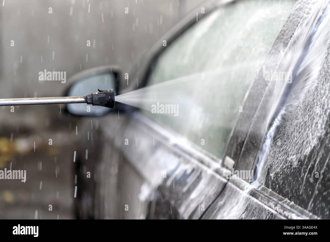 Lavare un'auto nell'autolavaggio con acqua e shampoo Foto Stock