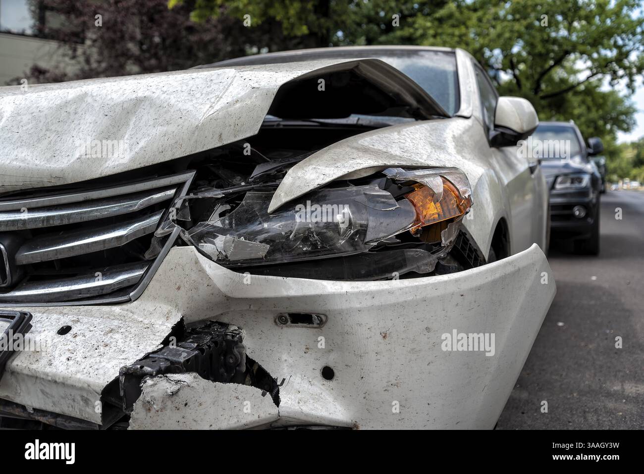 Vettura gravemente danneggiata sul lato della strada dopo un incidente Foto Stock