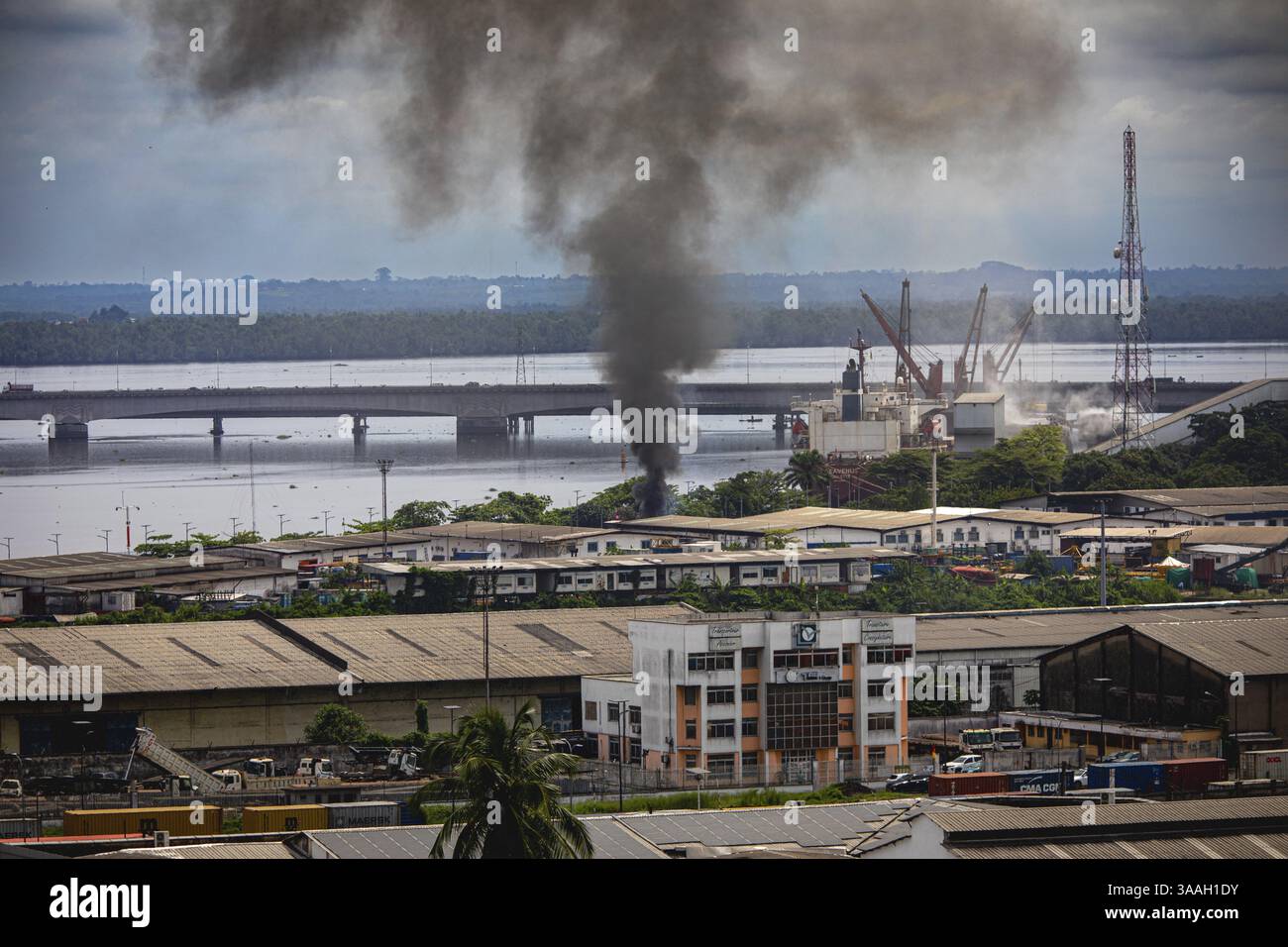 Fumo proveniente dalle attività industriali di Douala, dal porto marittimo, dai container impilati in alto e dallo skyline della città sullo sfondo. Trade, Douala, Cam Foto Stock