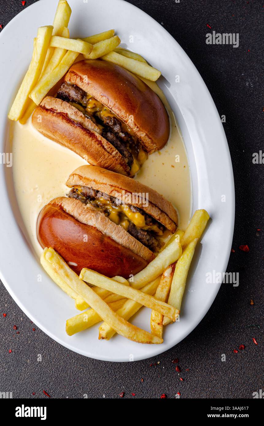 Burger con patatine fritte in salsa al formaggio Foto Stock