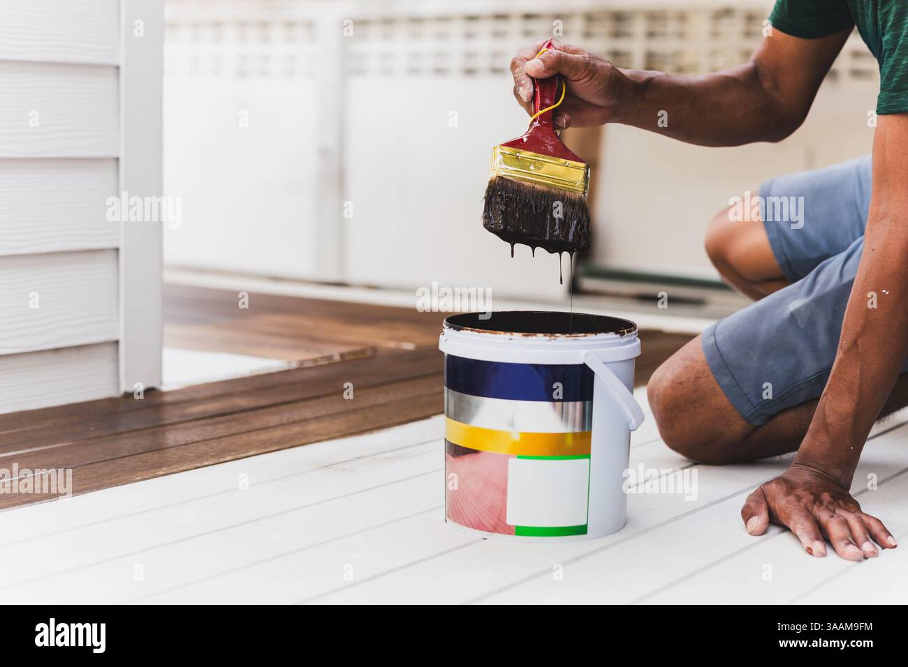 Tenendo a mano la boccola verniciata vernice anti-ruggine su acciaio decorato a casa. Foto Stock
