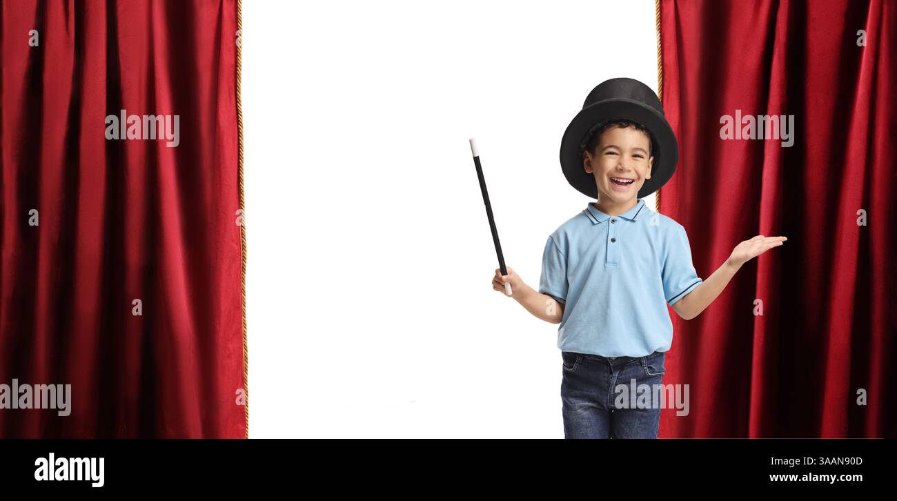 Ragazzo che indossa un cappello da mago e tiene in mano una bacchetta su un palcoscenico teatrale Foto Stock